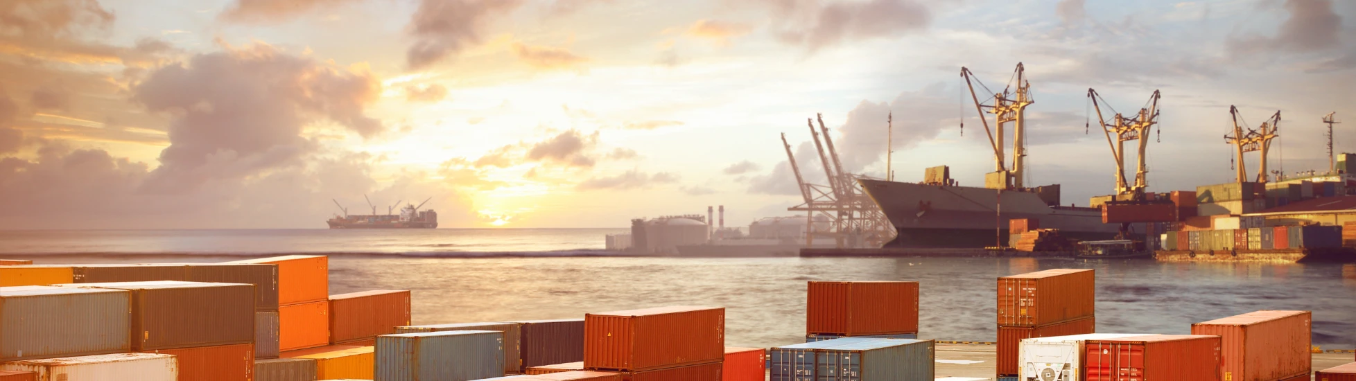 Shipping containers stacked up with sea in the background