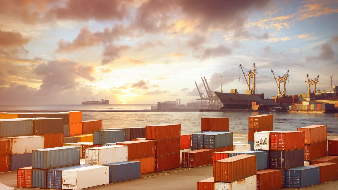 Shipping containers stacked up with sea in the background
