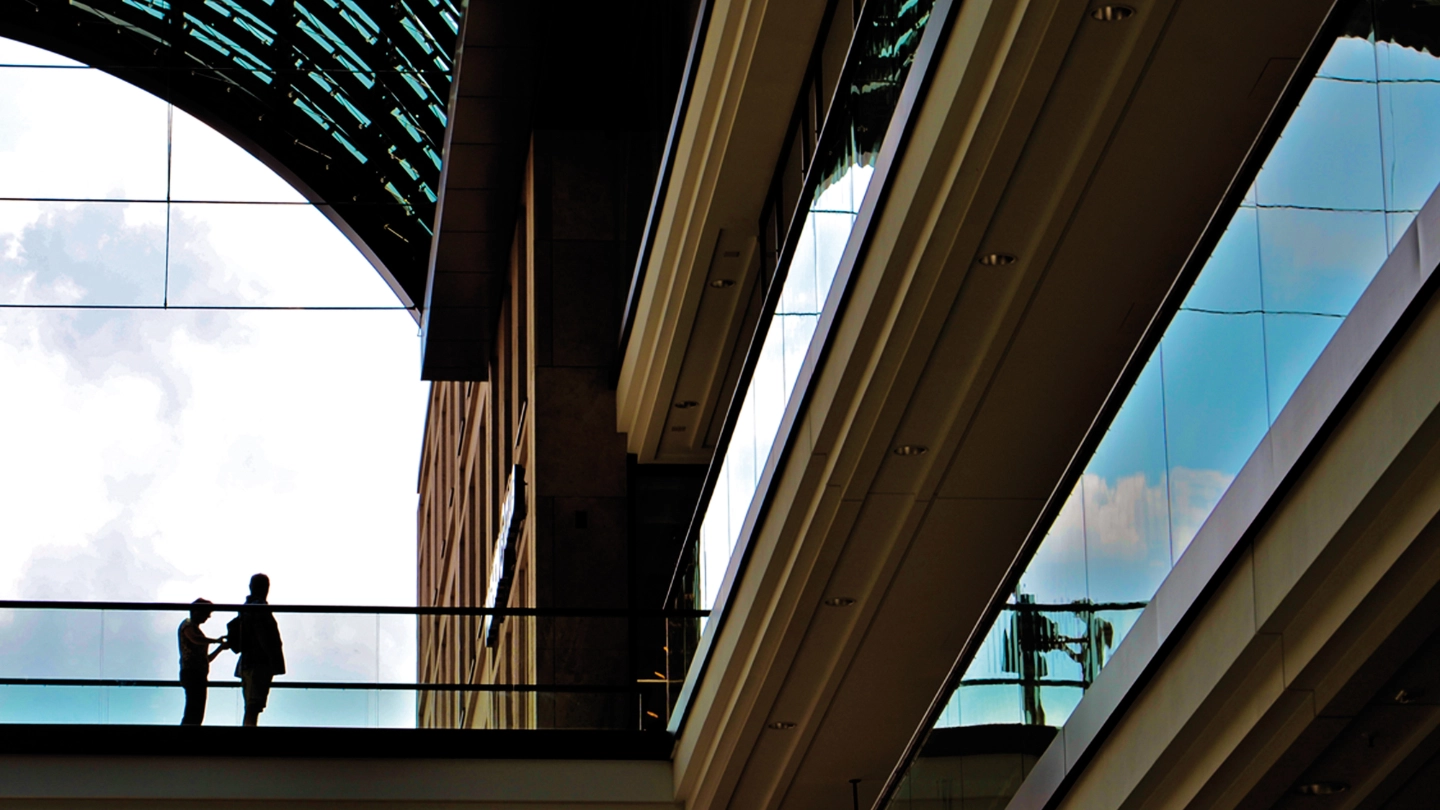 Architectural bridge with people in the distance two people standing under an arch of a building